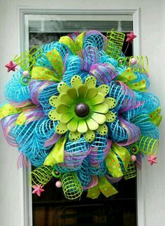 a blue and green mesh wreath hanging on a door with the words metal flower spring mesh wreath / turquoise lime pink