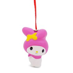 a pink hello kitty ornament hanging from a red string on a white background