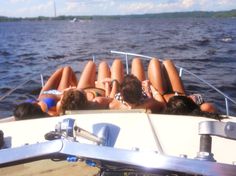 several people laying on the back of a boat