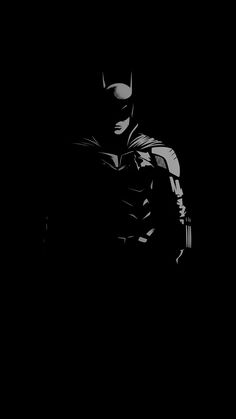 a black and white photo of batman in the dark