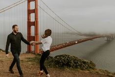 a man and woman dancing in front of the golden gate bridge