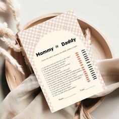 a card that reads mommy or daddy on the front and back of it next to some feathers