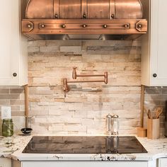 a stove top oven sitting inside of a kitchen next to white cabinets and counter tops