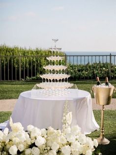 a wedding cake sitting on top of a table next to a vase filled with flowers