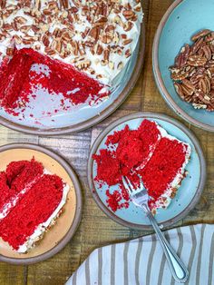 red velvet cake with white frosting and pecans on top, surrounded by other desserts