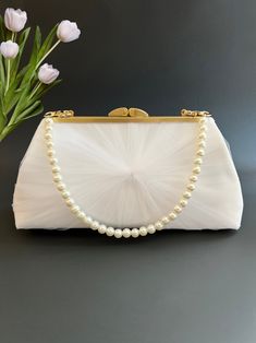 "Whether you're a bride getting ready to walk down the aisle, a bridesmaid supporting your dear friend, or a mother sharing in the joy of your loved one's special day, consider this tulle wedding clutch with a pearl strap. It's an accessory that marries elegance, personalization, and versatility flawlessly. What truly sets this clutch apart is its ability to be personalized. The interior lining can be customized with a photo of your choice, allowing you to carry a cherished memory with you on yo Elegant Evening Bridal Accessories With Tulle, Elegant Evening Bridal Accessories In Tulle, Elegant Evening Tulle Bridal Accessories, Elegant Tulle Bridal Accessories, Elegant Tulle Bridal Accessories For Evening, Cream Wedding Dress For Mother Of The Bride, Elegant White Wedding Dress For Ceremony, Elegant Tulle Wedding Dress For Bride, Elegant Organza Bridal Accessories For Ceremony