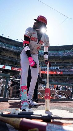 a baseball player holding a bat on top of a field in front of a crowd