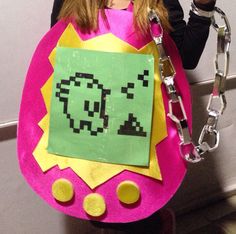 a girl in a pink costume holding a chain around her neck and wearing a pacman mask