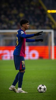 a man standing on top of a field next to a soccer ball in front of him