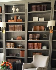 a living room filled with furniture and bookshelves covered in lots of bookcases