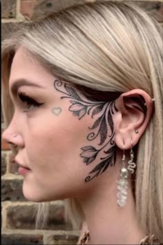 a woman with tattoos on her face and ear