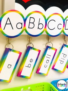 colorful name tags are hanging on the wall in front of a green basket and plastic bin