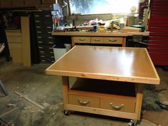 a workbench in a garage with lots of tools on the table and drawers