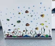 an aquarium scene with fish and bubbles on the wall