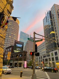 an intersection with traffic lights and tall buildings in the background at sunset or dawn,