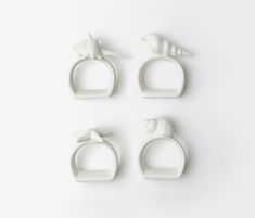 four white rings with birds on them sitting next to each other in front of a white background