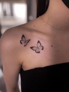 two butterflies on the back of a woman's shoulder