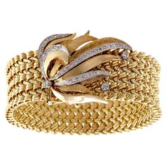 Beautiful Circa 1970 14k yellow gold and diamond spray wide flexible bracelet - sculpted floral leaf yellow gold diamond clasp set with three small round diamonds - wide heavy 14k yellow gold braided bracelet - hidden clasp - length 6 3/4" plus an additional piece to lengthen if needed - very good condition. Measurements: 6 3/4" Length (plus an additional piece if needed) Condition: Very Good Period: Circa 1970 Style: 70's Contemporary 1970 Style, Gold Bullion Bars, Diamond Cuff Bracelet, Flexible Bracelet, Retro Bracelet, Gold Link Bracelet, Bracelet Diamond, Antique Bracelets, Braided Bracelet