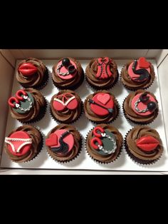 cupcakes decorated with red and black icing in a box