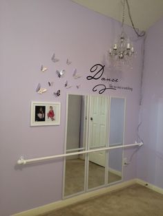 there is a mirror in the corner of this room with butterflies on the wall above it