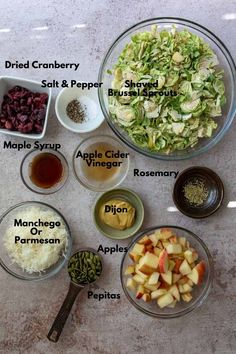 the ingredients for apple cider salad laid out in bowls on a marble counter top