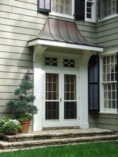 a white door and window in front of a house