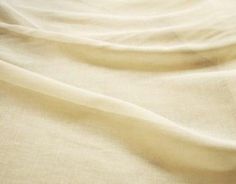 a close up view of a bed with white sheets