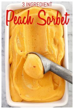 a scoop of peach sorbet in a white dish with a spoon on the side