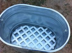 an empty metal tub sitting on the ground