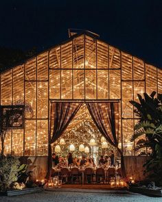 an outdoor wedding venue with lights on the roof and tables set up in front of it