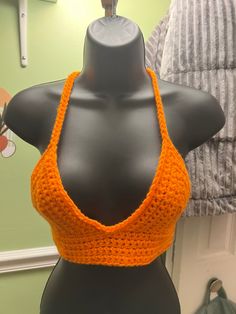 an orange halter top on a mannequin's dummy in front of a wall