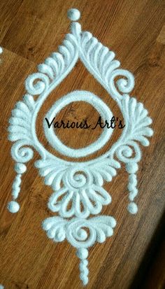 a wooden table topped with white paint and an ornate design on top of wood flooring