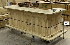 a large wooden box sitting on top of a pallet in a room filled with lumber