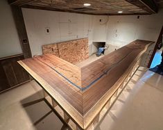 an unfinished wooden counter in the middle of a room