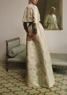 a woman standing in front of a mirror wearing a white dress and holding her hands on her hips