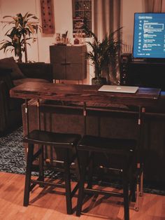 two stools sit in front of a table with a laptop on it