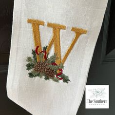 a towel hanging from the side of a door with pine cones and evergreens on it