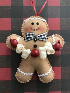 a gingerbread man ornament hanging on a red and black checkered wall