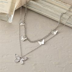 A cluster of dainty butterflies adorns the shorter chain of this layered necklace while a single textured butterfly graces the longer. Long chain: 15.75" L with 2.36" extender Short chain: 13.98" L Pendant: 0.67" L Lobster claw clasp Silver-plated copper