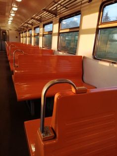 an empty train car with red seats and railings