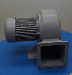 an industrial blower sitting on top of a blue mat