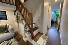 a living room with stairs leading up to the second floor and a couch next to it