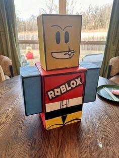 a cardboard robot sitting on top of a wooden table