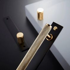 a close up of a metal object on a black surface with gold accents and knobs