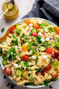 a pasta salad with tomatoes, cucumbers and other vegetables