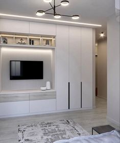 a living room with white furniture and lights on the wall, along with a flat screen tv