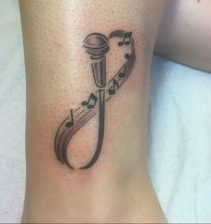 a tattoo on the leg of a woman with musical notes and a trellophone