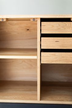 an open wooden cabinet with drawers and shelves