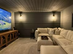 a living room filled with furniture and a flat screen tv mounted to the side of a wall