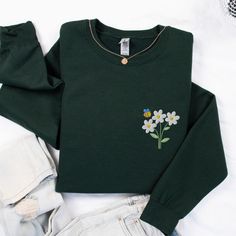 IF YOU ARE ORDERING TODAY, IT IS NOT GUARANTEED TO MAKE IT BY CHRISTMAS. THE HOLIDAY ORDER DEADLINE WAS DECEMBER 8TH. This unisex Gildan cozy Spring embroidered daisies sweatshirt is trendy, comfortable and versatile and perfect to wear for a variety of looks - classic and cozy or oversized with the sleeves rolled up for a trendy, casual look!  It's going to be your new closet favorite and an item that you always seem to reach for!  It makes a great April birth month flower birthday gift, a cute Green Long Sleeve Sweatshirt With Letter Embroidery, Green Long Sleeve Sweatshirt With Embroidered Graphics, Green Embroidered Long Sleeve Sweatshirt, Cute Embroidered Sweatshirt For Loungewear, Green Long Sleeve Sweatshirt With Custom Embroidery, Green Long Sleeve Sweater With Embroidered Text, Cute Crew Neck Embroidered Sweatshirt, Cute Cotton Sweater With Floral Embroidery, Green Cotton Sweater With Embroidered Graphics